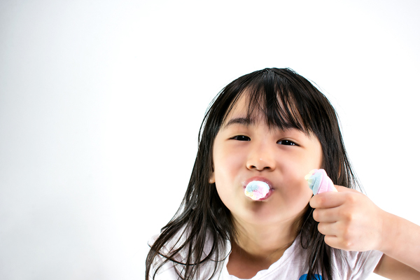 Child eating two marshmellows